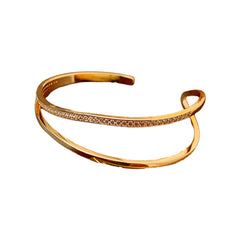 Gold-tone Celeste zirconia open bangle bracelet on a white background