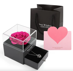 Black gift box with pink rose, necklace, and heart-shaped card on a white background