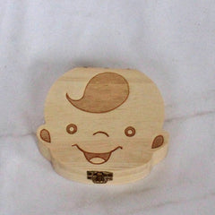 Wooden box shaped like a baby's head with a smiling face on a white background