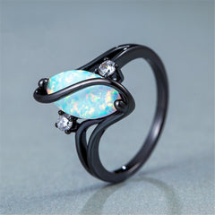 Ring with black band and blue opal stone on a light gray background