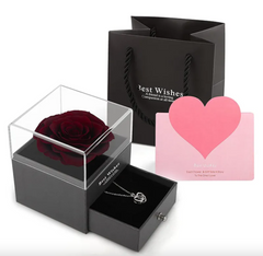 Black gift box with a red rose, necklace, and pink heart card on a white background