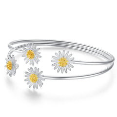 Silver bracelet with daisy flower designs on a white background