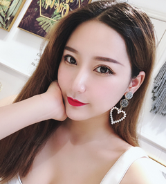 Woman wearing heart-shaped earrings with a blurred background