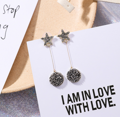 Star-shaped rhinestone pearl drop earrings displayed on a gift card